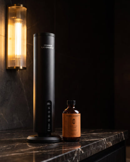 Grande Lavendera Smart App Waterless Aroma Diffuser with 4 oz Moroccan Amber diffuser oil on dark marble at night